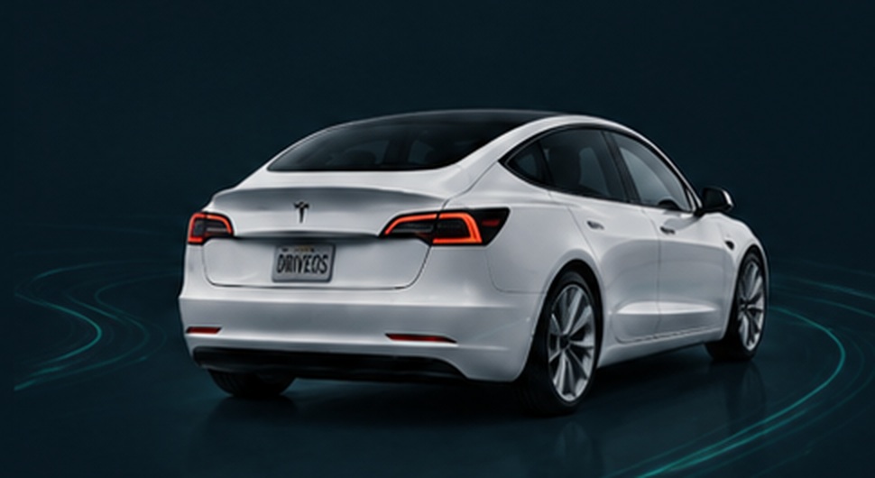 White Tesla Model 3 on a dark roadway